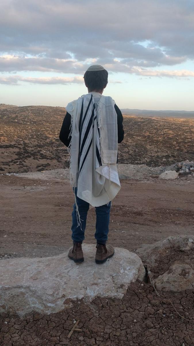 בנה של אורית עם הטלית שהוריש לו ניצול השואה (צילום: דוברות מכבי)